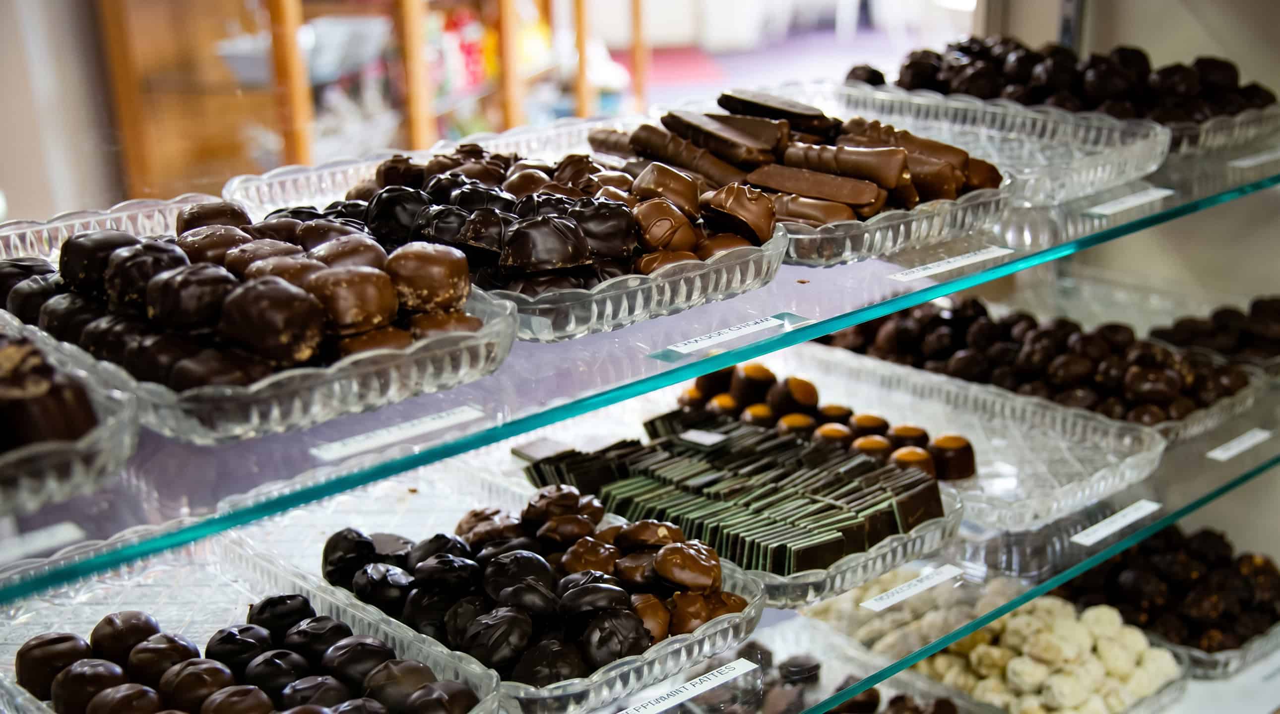 A bakery case filled with rows of hand-dipped chocolates and confections